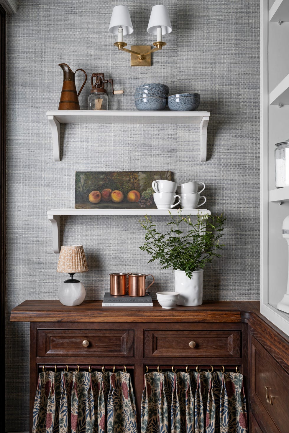 Bestückte Regale gegenüber der Spülküche und eine begehbare Speisekammer halten Kleingeräte und Küchenutensilien von Wayfair in Reichweite. Die festen unteren Regale sind mit Caesarstone verkleidet, während die oberen Regale verstellbar sind