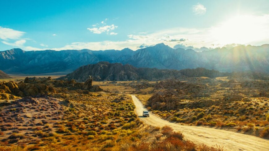 Auto auf unbefestigter Straße, Bergkette, Dünen, Wüste