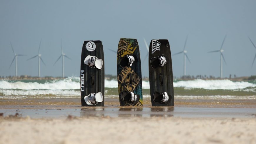 Surfbretter im Sand an einem Strand, Windkraftanlagen, Wellen, klarer Himmel