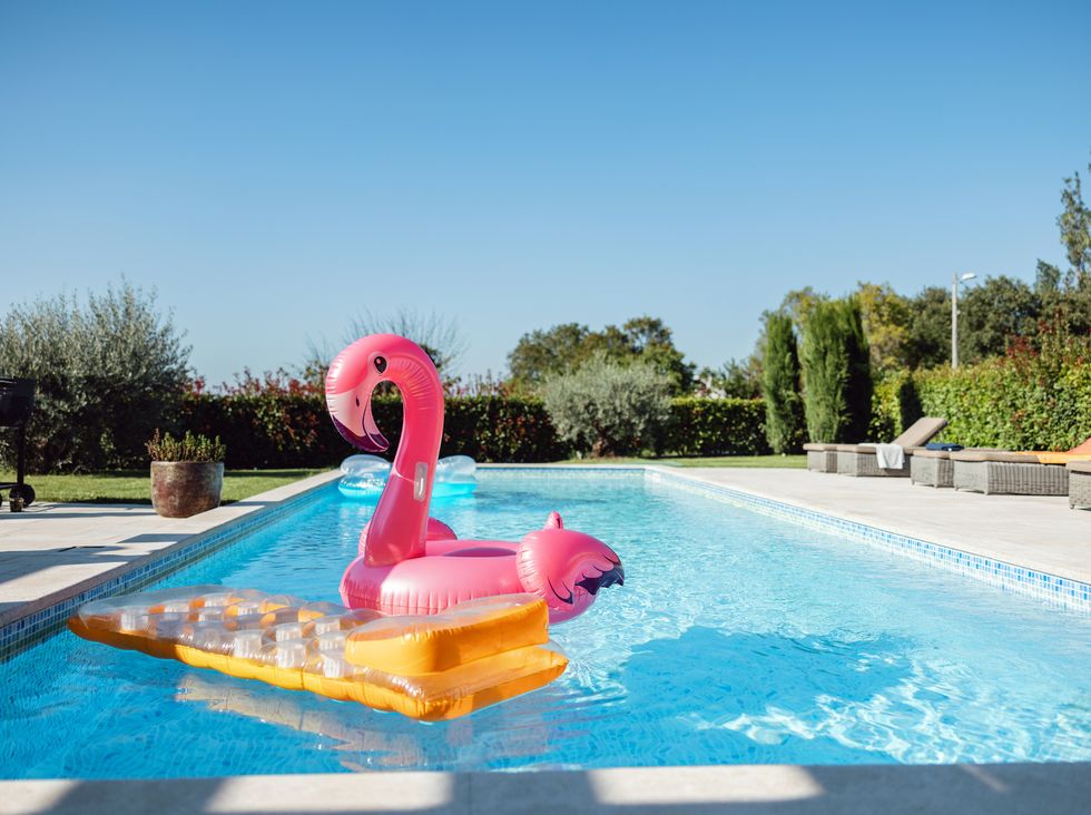Verschiedene Poolschwimmer, die in einem leeren Pool schweben