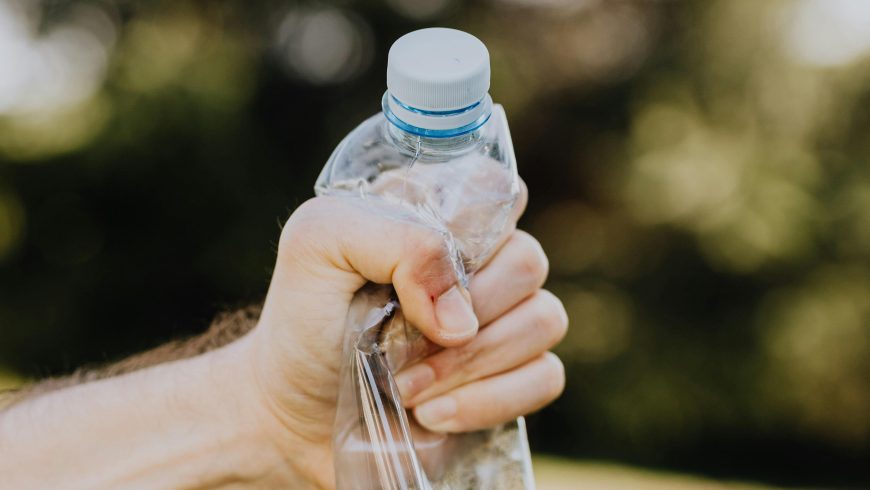 Ernte männliche Plastikwasserflasche auf dem Campus