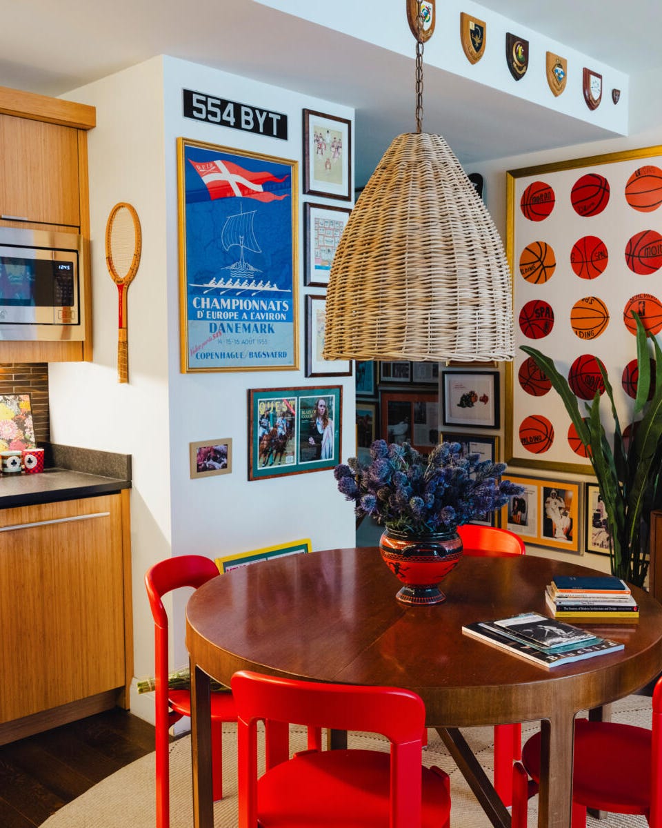 Ein gemütlicher Innenraum mit einem Essbereich mit roten Stühlen und einem runden Tisch in einer Küchenecke und verschiedenen dekorativen Elementen