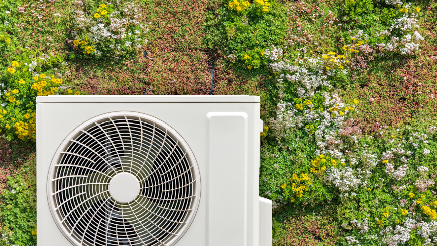 Energieeffiziente Wärmepumpe an einer grünen Wand