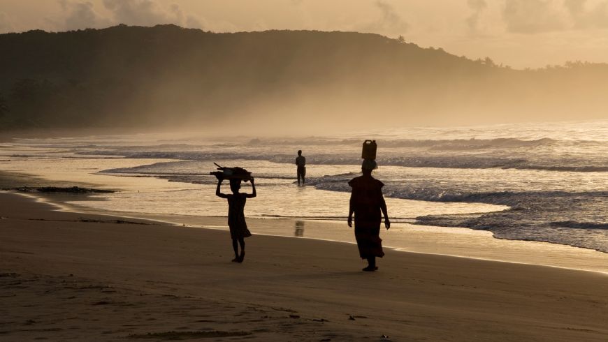 Menschen, die am Strand in Ghana spazieren gehen
