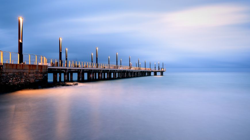 Der Pier auf halber Strecke am Strand, während der Sonnenuntergangsstunde