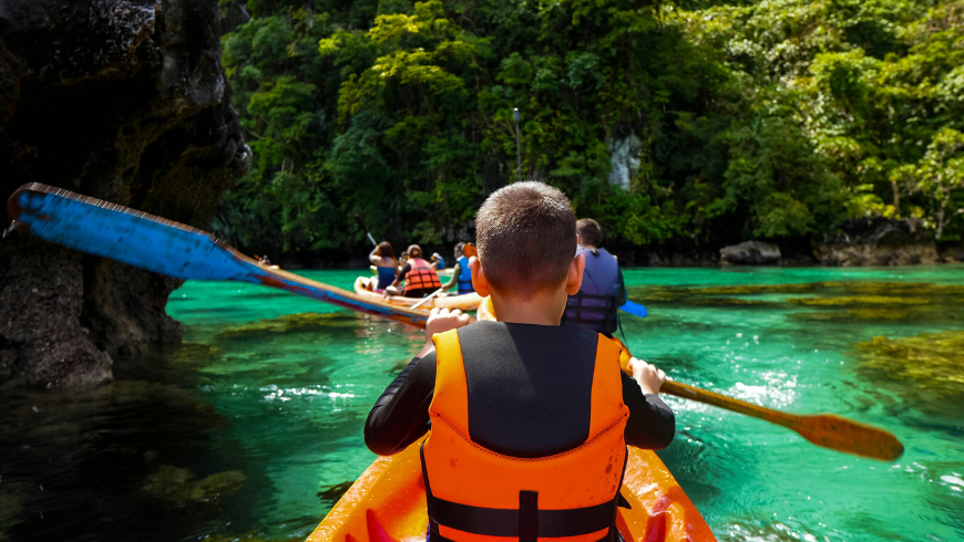 Kinder fahren Kajak in einem Fluss