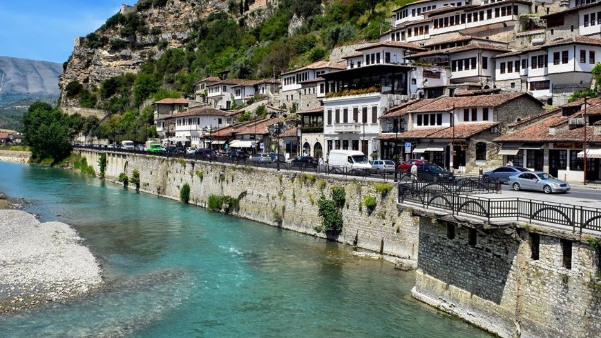 Berat, wo der Osum unterhalb des Osmanischen Viertels verläuft. Die Stadt ist durch regelmäßige Intercity-Verbindungen mit Tirana verbunden.